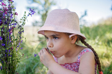 Girl in summer linen dress walking among trees in the forest and gathering wild flowers bouquet, slow living in the village, far from the big city, healthy lifestyle