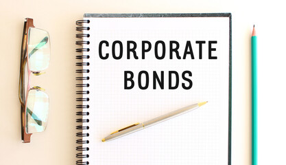 Notepad with text CORPORATE BONDS on a white background, near glasses and pencil.