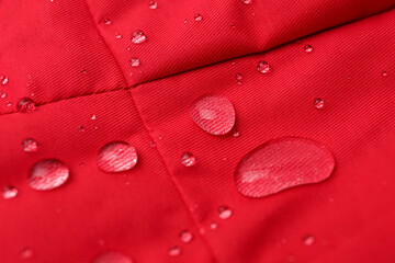 Fototapeta premium Red waterproof fabric with water drops as background, closeup