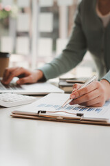 Businessman is inspecting the business reports graphs to audit the financial reports. Analyzing the revenue and auditing the budget concept.