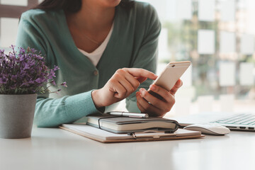 Fototapeta premium Women work at home and use smartphones and laptops to communicate, surf the internet or shop online, work from home concept.