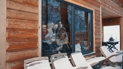 Women, best friends spending winter vacation in wooden mountain house. Drinking hot beverages and...