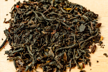 Delicious Black tea flavored with safflowers petals and bergamot pronounced taste. Selected focus Macro close up photography of tea leaves background. Sharp and vivid colors, ideal for advertising. 