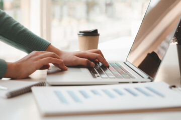 Business woman working and typing on laptop computer on the table.