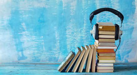 audio book concept with stacks of books and vintage headphones,literature,entertainment,education,...