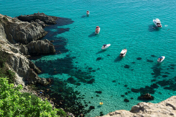 Top view of beautiful crystal clear water and white beach with boats in summer.