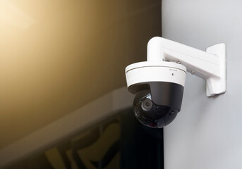 Modern public CCTV camera on the wall with blur building background. Recording cameras for...