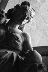 Ancient statue of woman with skull as symbol of figure of Death and end of human life.