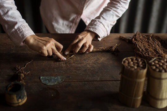 Hands of a woman rolling a cuban cigar in a beautfiul ambient. Vinales, Cuba