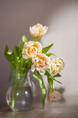 Bouquet of tulips in glass vase under the table. Copy space.
