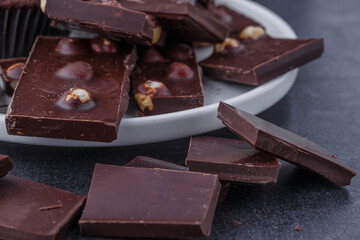 Chocolate cupcake with icing and chocolate bar in Dark lighting,Homemade delicious chocolate muffin on wooden background close-up