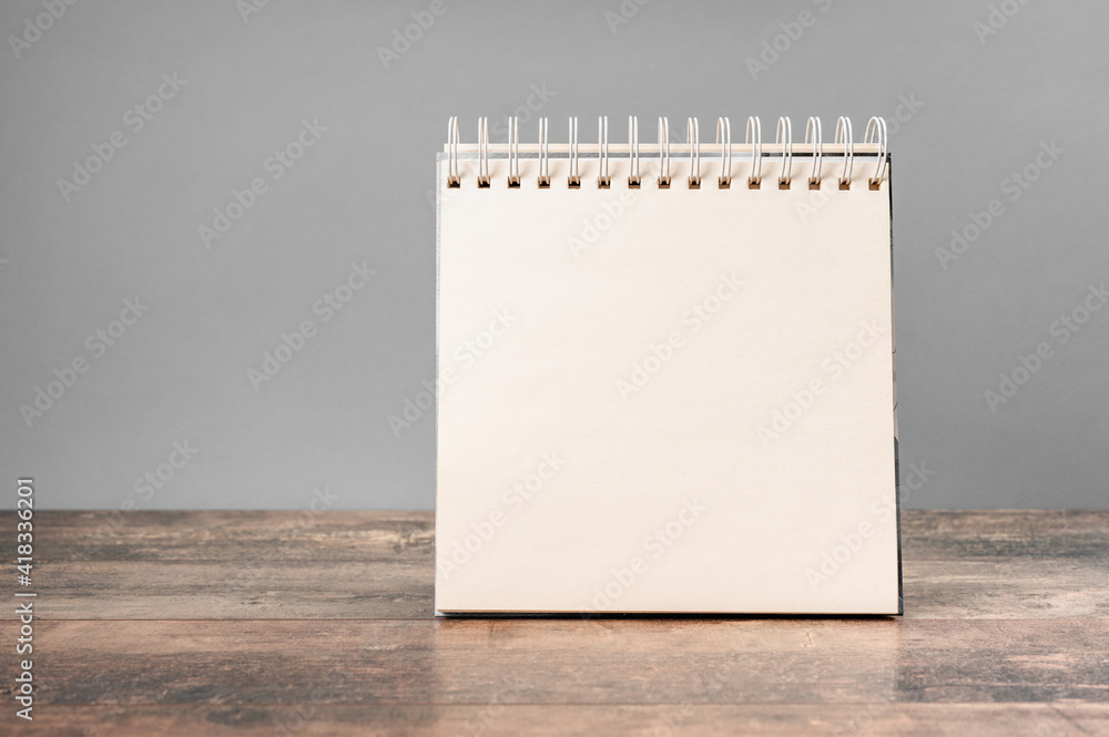 Aufkleber mockup notepad. blank spiral bound notepad mockup with on light grey background and wooden table.