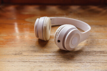 Obraz na płótnie Canvas White headphones on wooden background. Music concept.