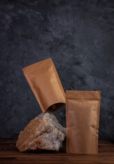 Balancing pouch bag mockup on natural stone. Blank kraft paper pack with coffee beans dark...