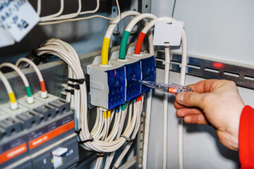 Checking the electrical distributor with an indicator screwdriver. Detection of voltage in the switchboard with special equipment. Close-up