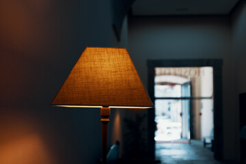 orange lampshade in front of blurred open window