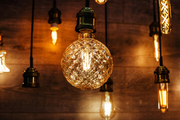 Light bulb with corrugated glass. Small faceted chandelier in a shop window. Selection and comparison of lighting equipment in the retail network. Close-up