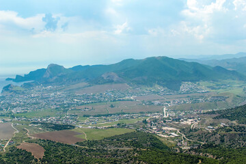 Obraz premium Panorama of the Crimean mountains overlooking the city of Sudak on a sunny day.