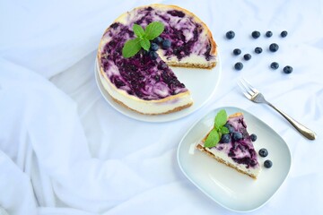 Blueberry cheesecake with mint leaf on white background