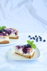 Blueberry cheesecake with mint leaf on white background