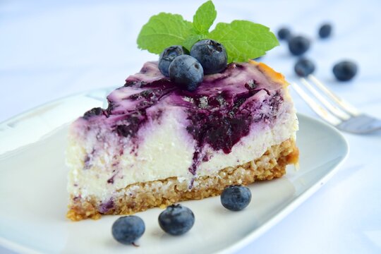Blueberry cheesecake with mint leaf on white background. Selective focus