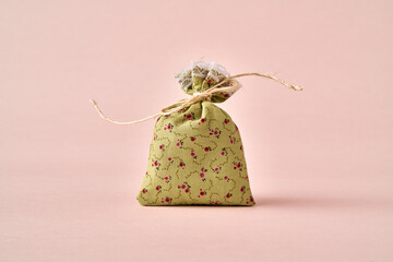 Small green cotton bag on a pink paper background