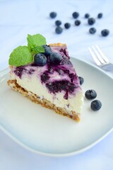 Blueberry cheesecake with mint leaf on white background. Selective focus