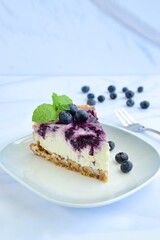 Blueberry cheesecake with mint leaf on white background