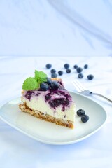Blueberry cheesecake with mint leaf on white background