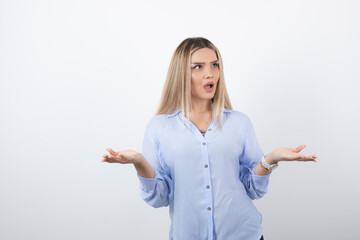 Young woman in casual outfit looking at someone on white background