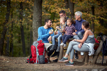 Cheerful family having fruit snack in forest
