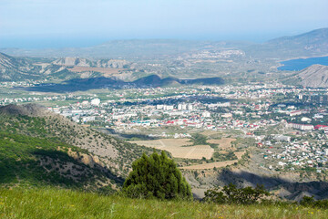 Fototapeta na wymiar Panorama of the Crimean mountains with a view of the city of Sudak. Fortress view from the mountain on a sunny day.