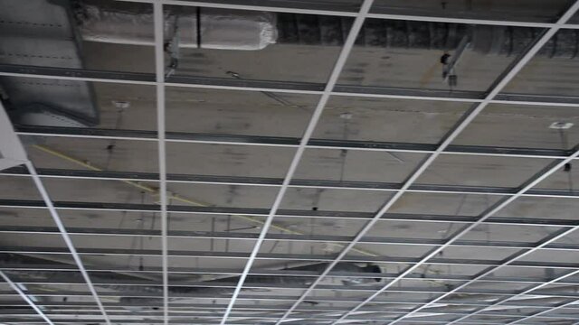 Panning over bare suspended ceiling frame on construction site