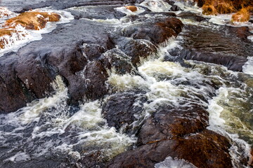 Fast river with ice in late autumn