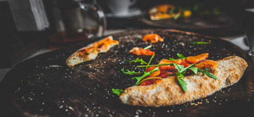 The last slice of pizza on black wooden board in cafe