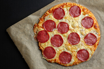 Pizza with salami and cheese on dark