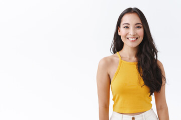 Waist-up enthusiastic asian female with long dark hair, wear yellow trendy top, smiling with...