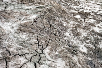 A web of cracks in the gray sand in autumn. Background