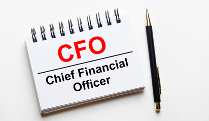 On a light background, a white notebook with are words CFO Chief Financial Officer and a pen.