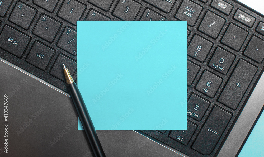 Poster on a computer keyboard, a pen and a blue sticker with space to insert text or illustrations. flat la