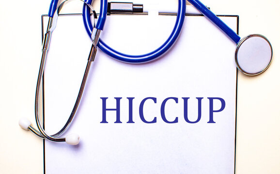 The word HICCUP is written on a white sheet near the stethoscope. Medical concept