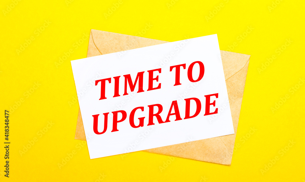 Poster on a yellow background, an envelope and a card with the text time to upgrade. view from above