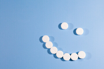 Pills positive smile on light blue background