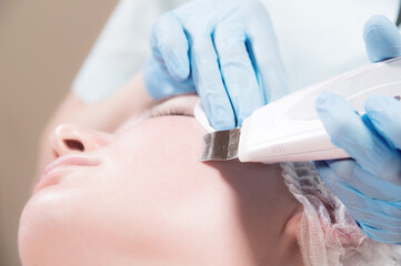 Close-up Professional face cleaning. Mechanical ultrasonic face cleansing procedure. Peeling of the skin of the face.