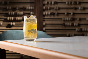 Highball cocktail with lemon peel, anise and ice on the table at restaurant