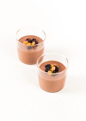 Vegan dessert, Panna Cotta made of gold and black raisins in a glass on a white background