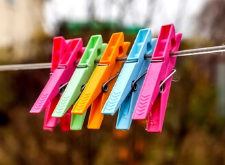 Colored clothespins on a rope close-up on a colored background