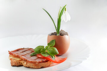 baguette slice with cheese, pork loin pastrami, basil leaves and a slice of tomato 