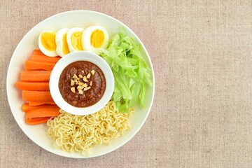 Gado-gado, traditional Indonesian salad with peanut sauce on brown background
