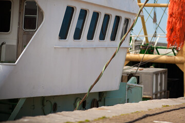 Wheelhouse and deck of a white fishing boat moored in a harbour © Bjorn B